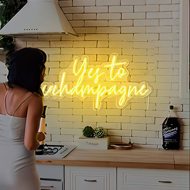 Yes to champagne neon sign for home in bright yellow LED lights with woman standing on left