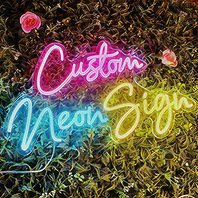 Custom neon sign in pink, blue and yellow on a grass wall background