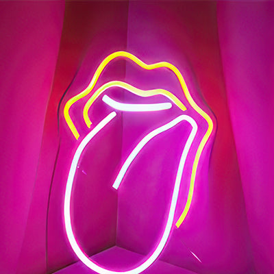 Woman's tongue out neon sign in yellow and pink lights