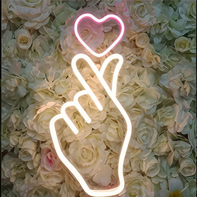 Neon sign of a hand holding a love hear in pink and warm white LED